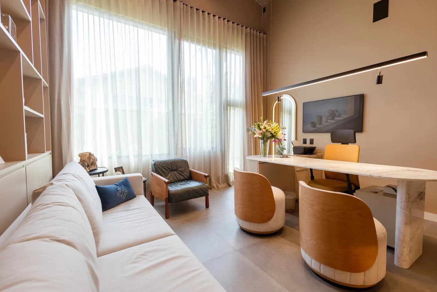 Sala de consulta com mesa de mármore, sofá e cadeiras de design
