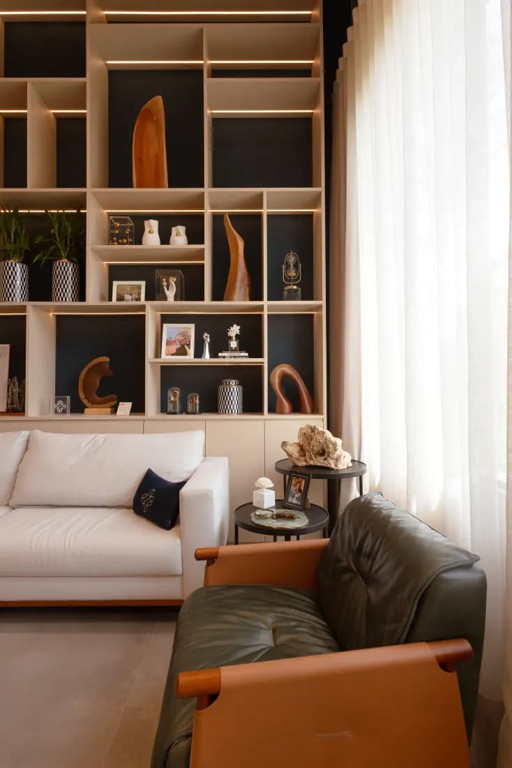 Detalhe da sala de espera, com poltrona de couro e estante