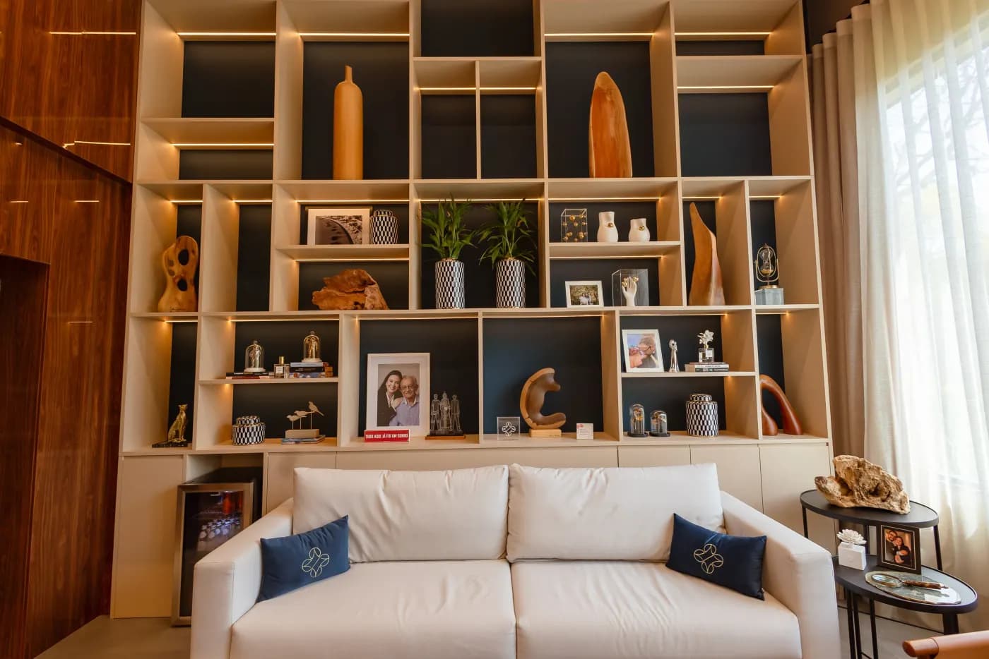 Sala de espera com estante curada e sofá branco